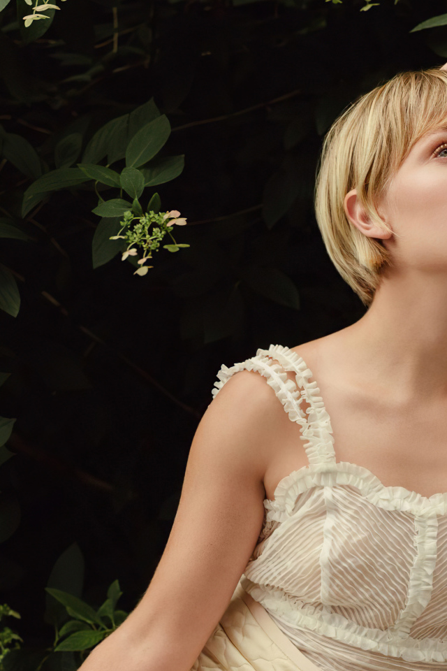 Актриса Аннасофия Робб сидит на стуле в саду