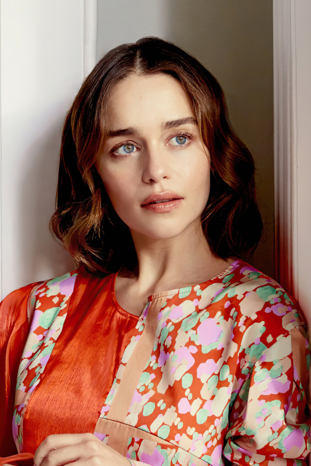 Актриса Эмилия Кларк в платье стоит у стены