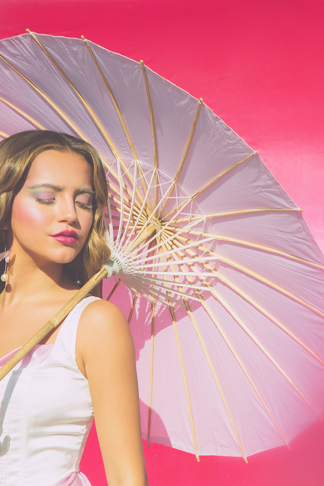 Актриса Изабелла Монер с белым зонтом на розовом фоне