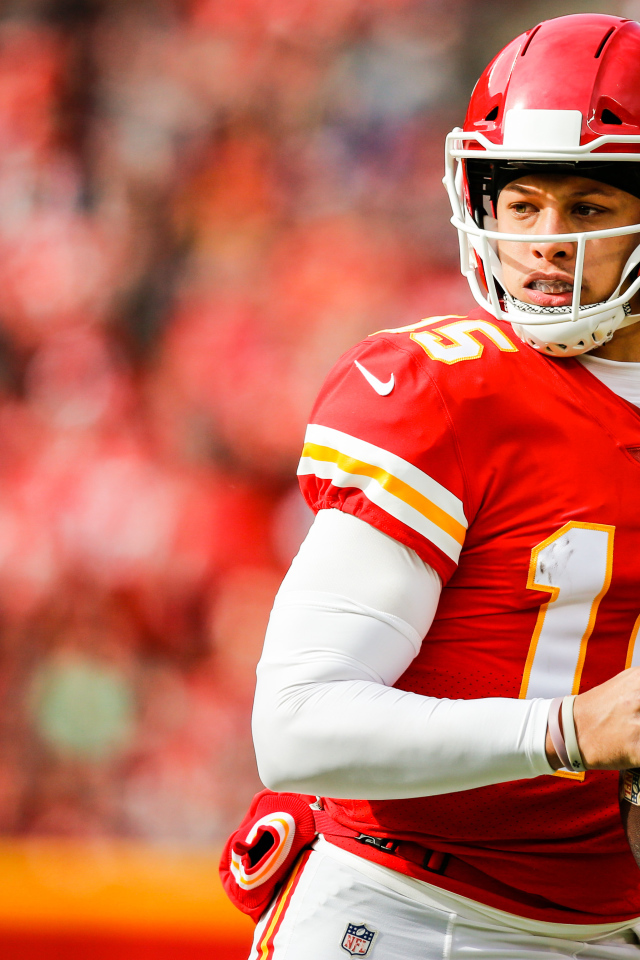 Игрок в американский футбол Патрик Махоумс на поле с мячом