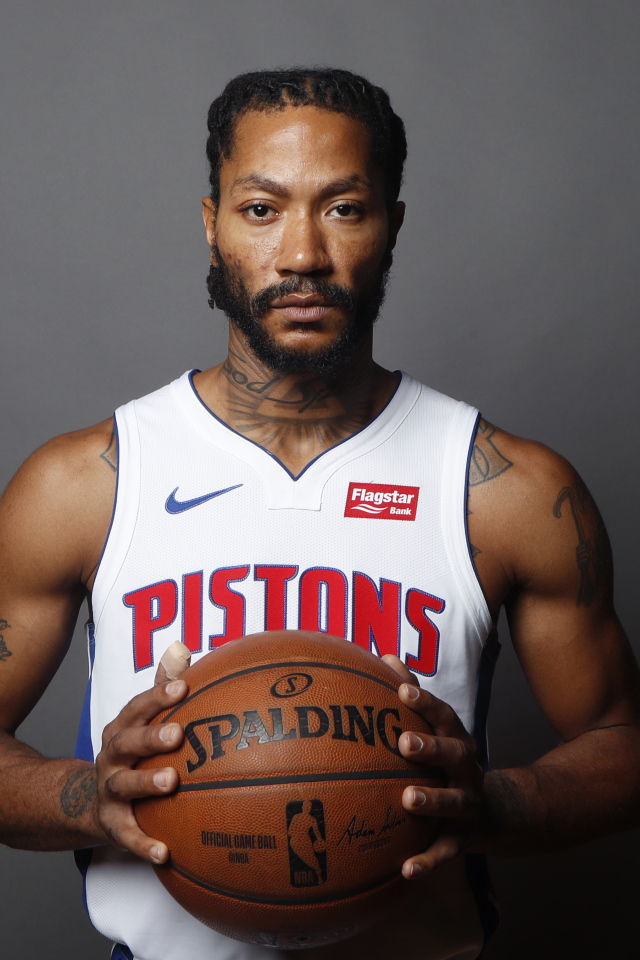 Баскетболист Деррик Роуз в мячом в руках на сером фоне