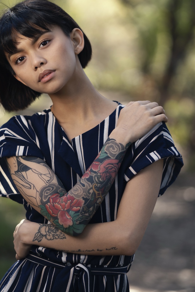 Красивая девушка азиатка с татуировками на руках 