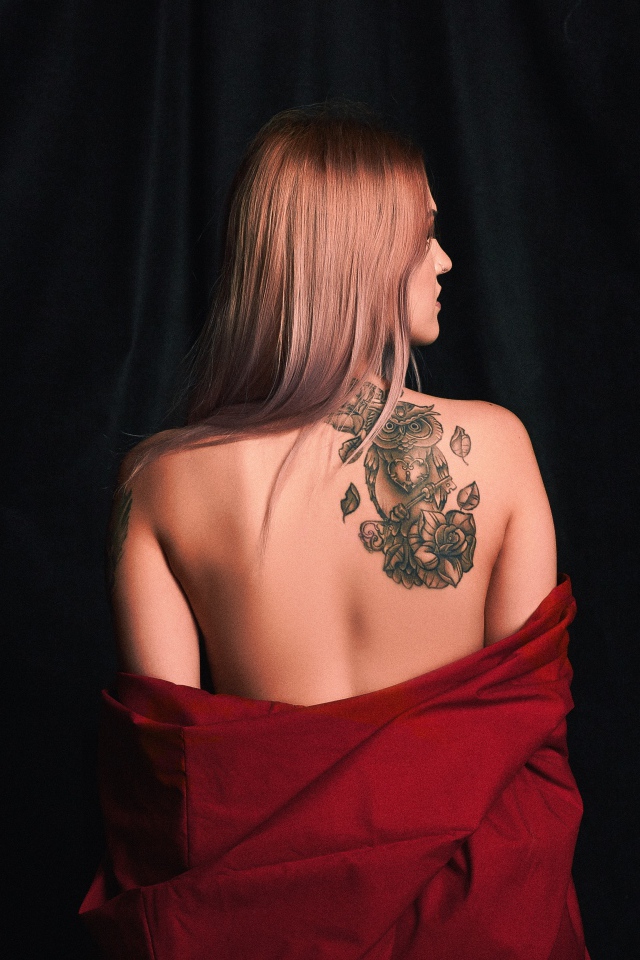 Красивая татуировка совы на спине у молодой девушки