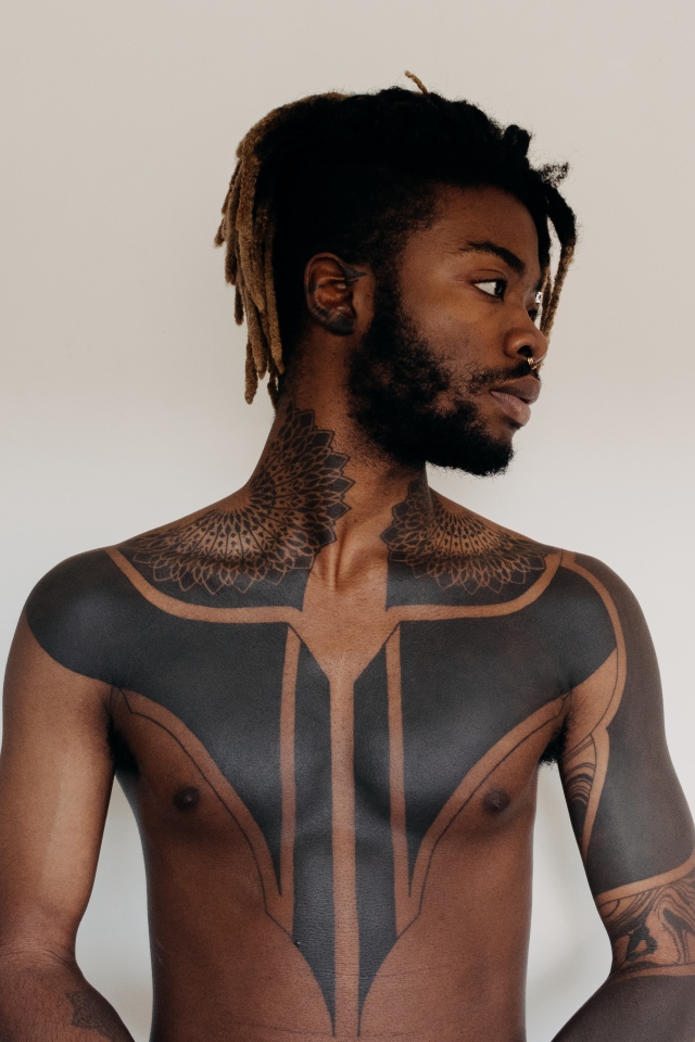 Темнокожий мужчина с татуировками на теле