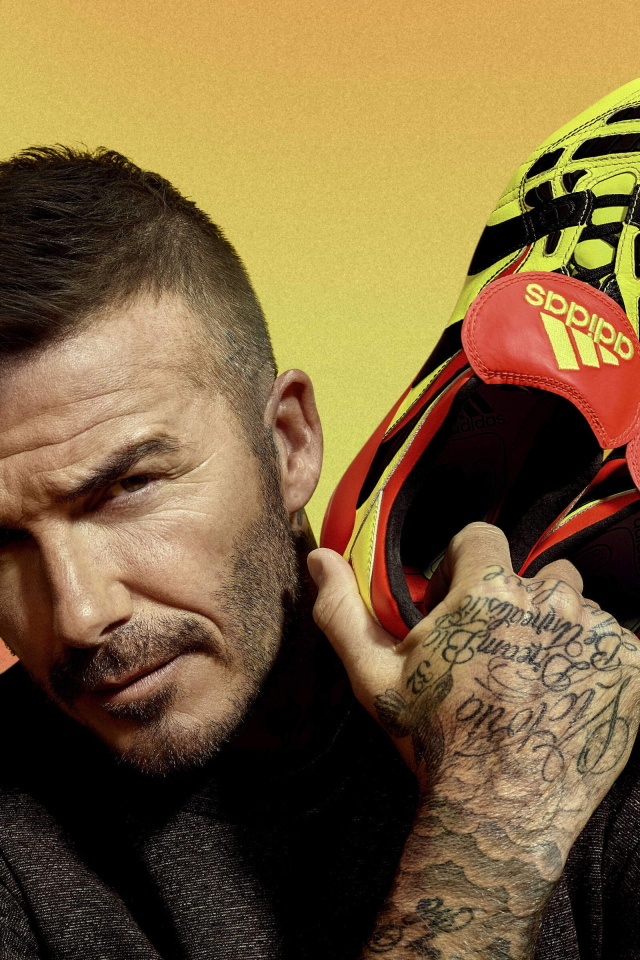 Футболист Дэвид Бекхэм с кедами Адидас в руке