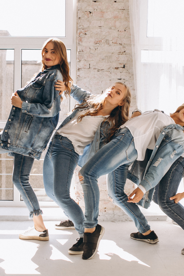 Четыре девушки в джинсовых костюмах занимаются танцами