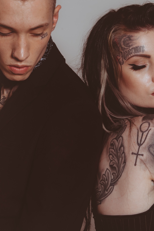 Девушка и парень с татуировками на теле на сером фоне