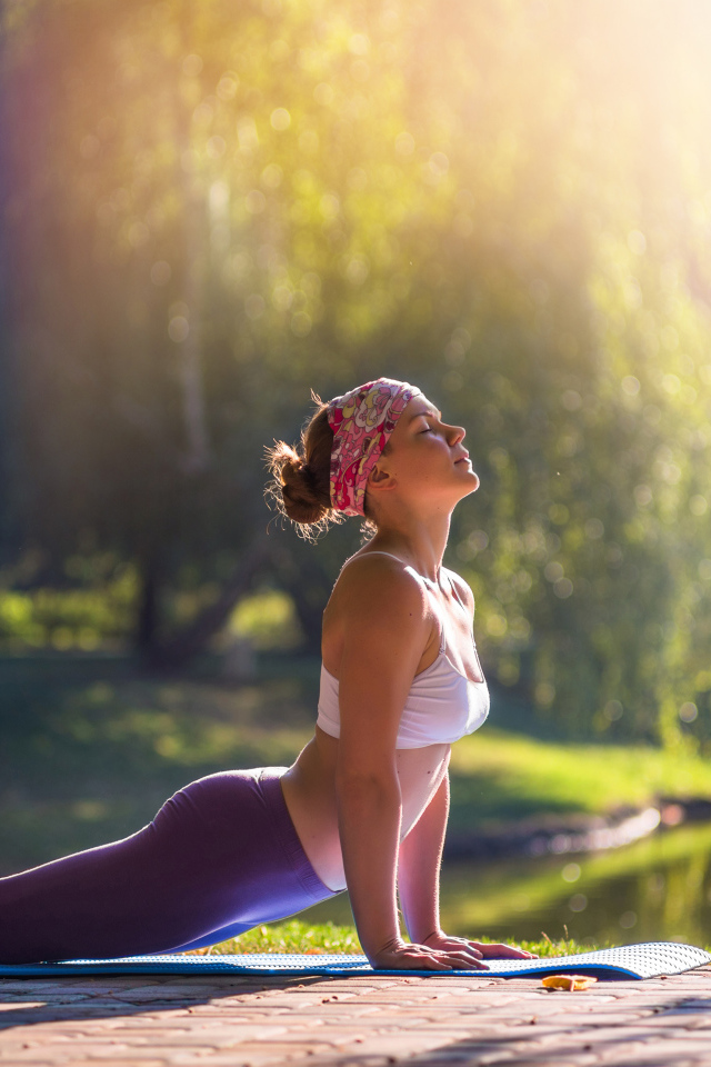 Девушка занимается йогой на природе 
