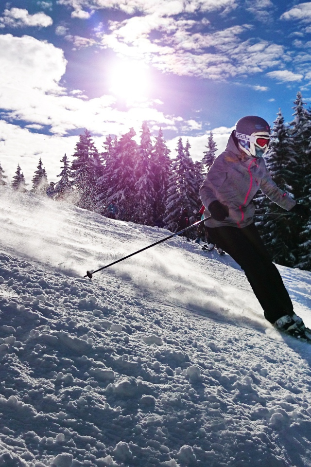 Девушка спускается на лыжах с горы