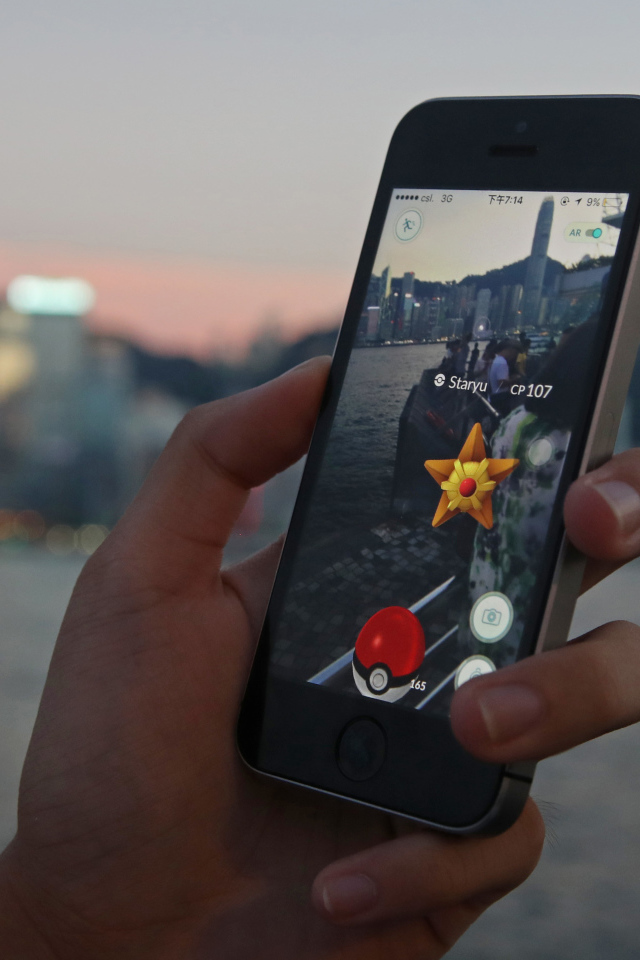 Guy catches Pokemon on a smartphone