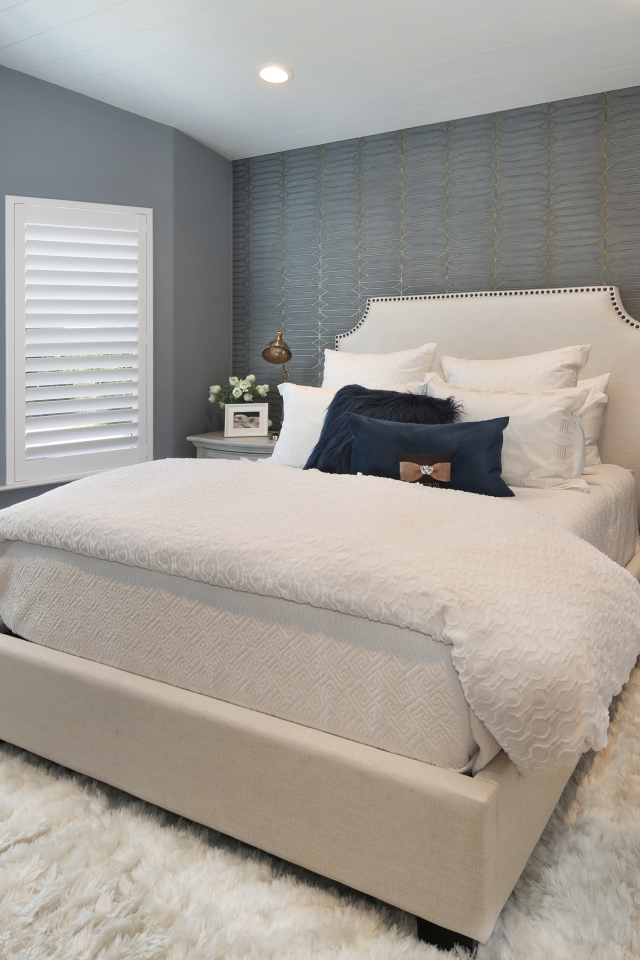 Высокая кровать в спальной комнате в серых тонах