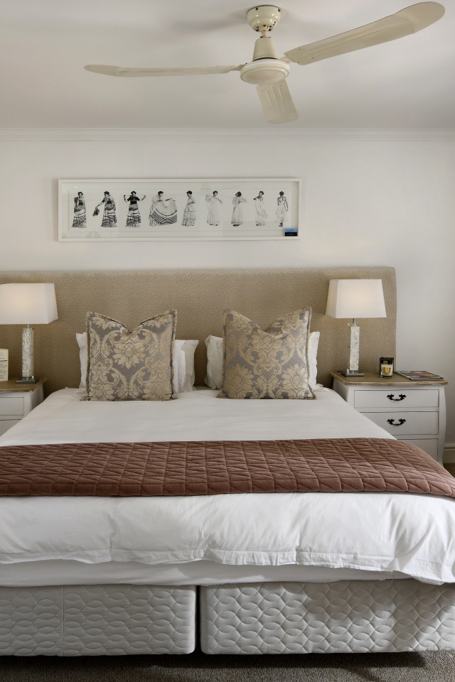 Большая кровать в спальне с вентилятором