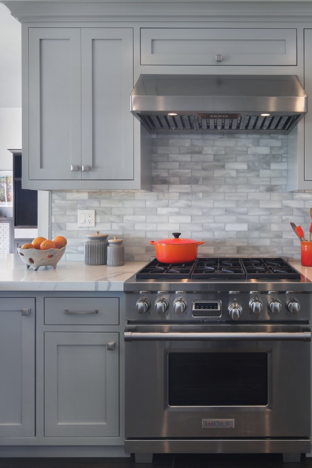 Большая газовая плита в серой кухне 