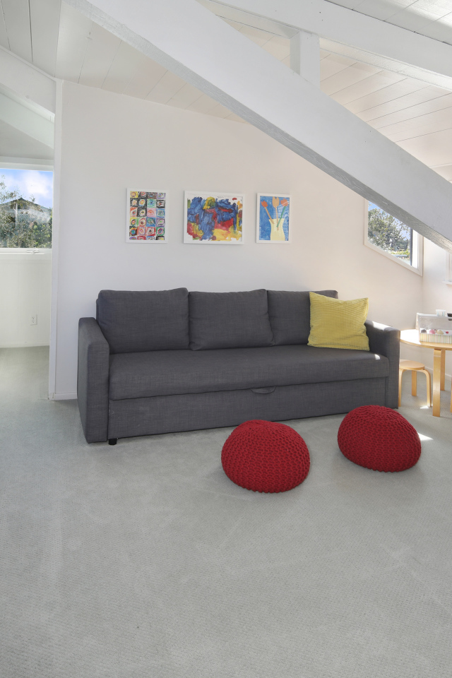 Большой серый диван в белой гостиной комнате