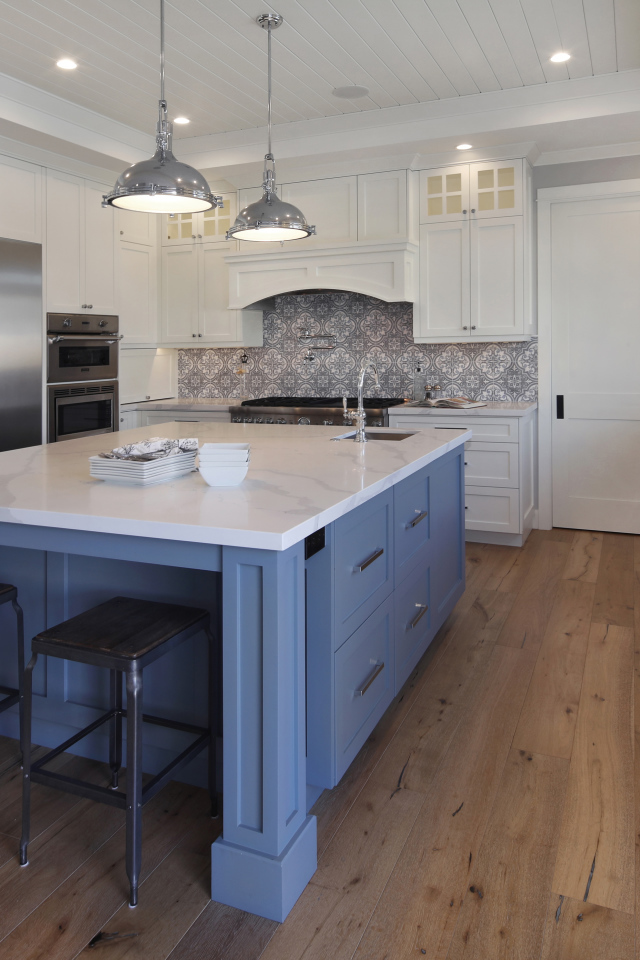 Большой серый стол в просторной белой кухне 