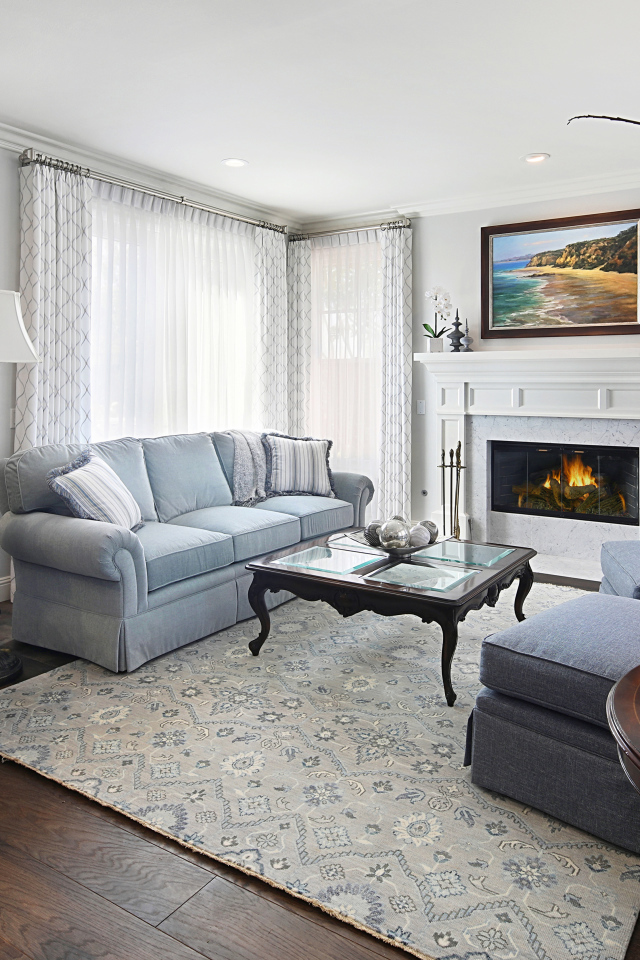 Большая гостиная комната с камином и живыми цветами