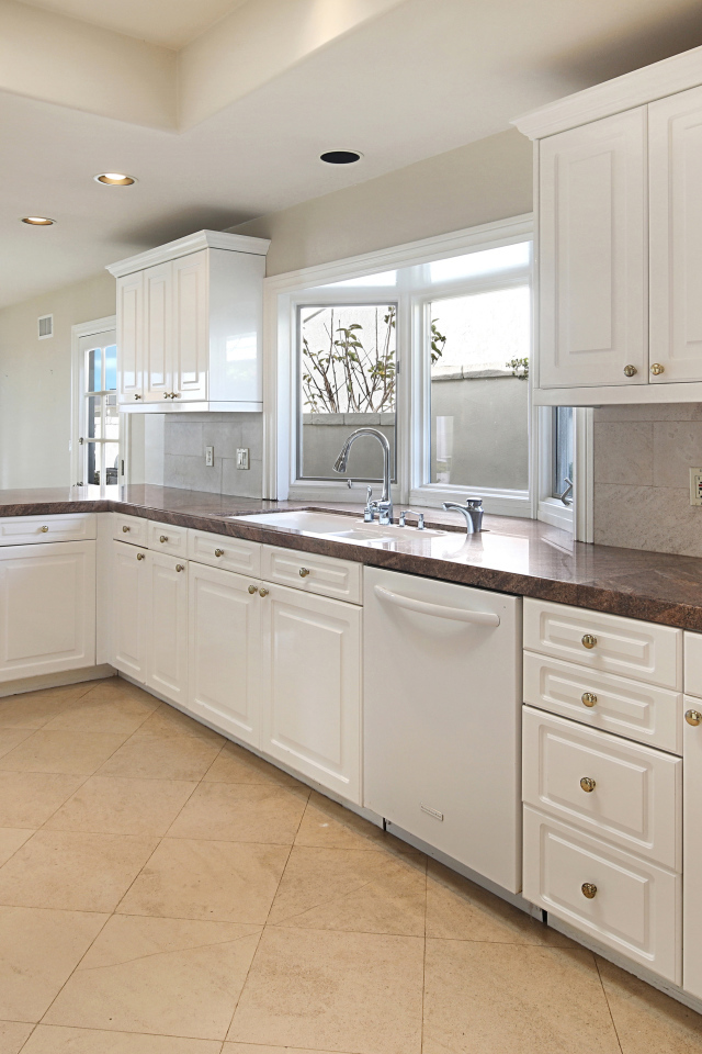 Большая белая кухня с окнами 