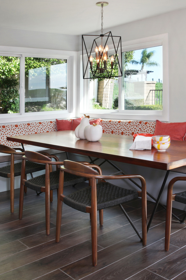 Большой деревянный стол и диван у окна в гостиной 