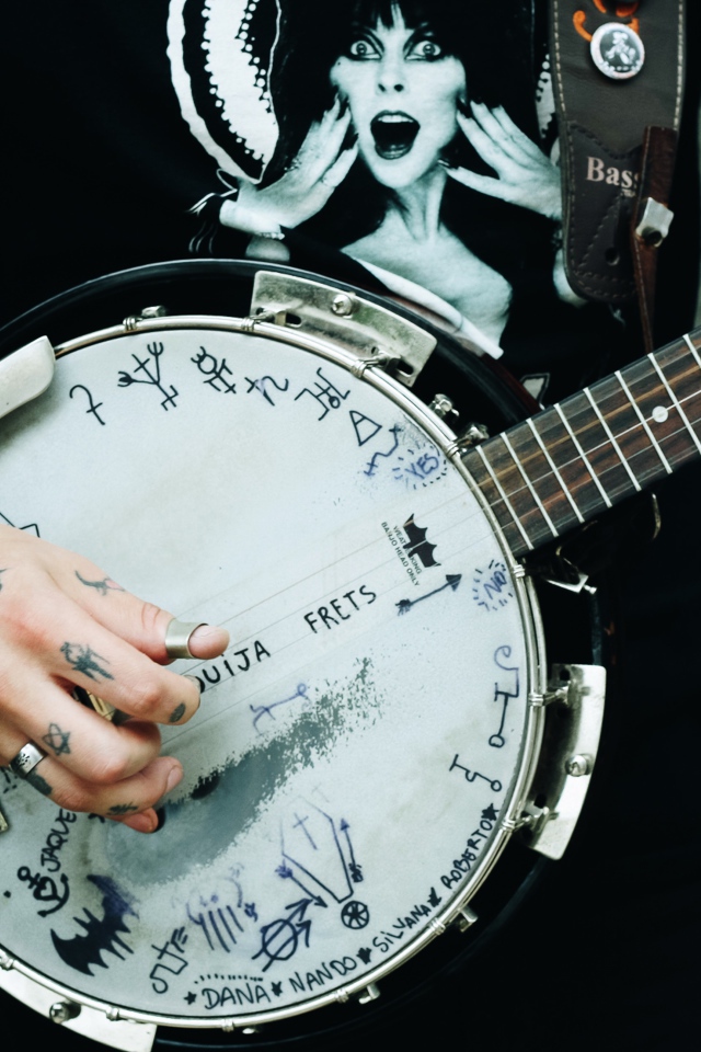 Мужчина с татуировками на руках с гитарой