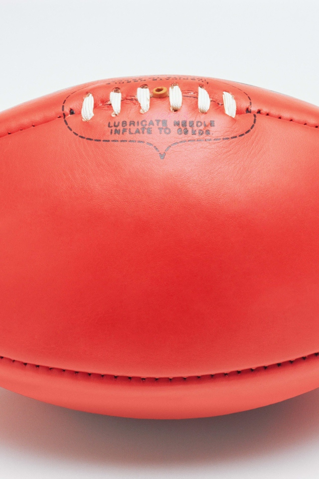 Красный мяч для американского футбола на белом фоне 