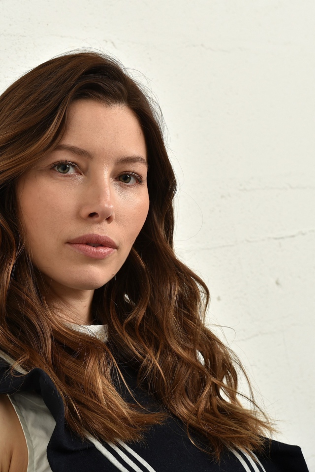 Грустная актриса Джессика Бил сидит у стены