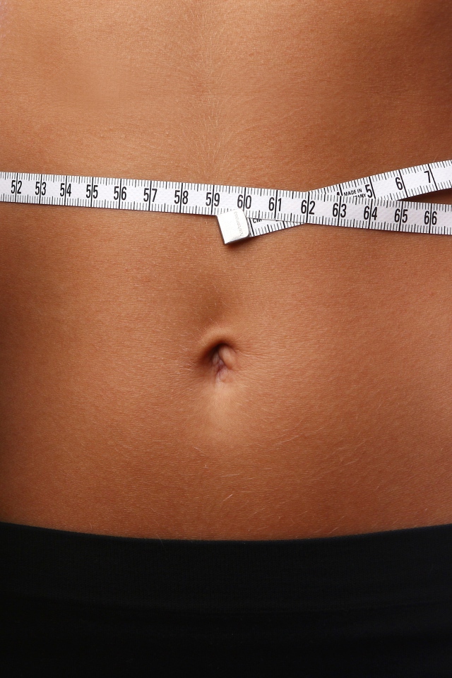 Стройная спортивная девушка с гантелями в руках 