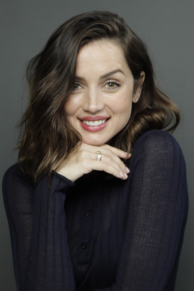 Улыбающаяся актриса Ана де Армас на сером фоне