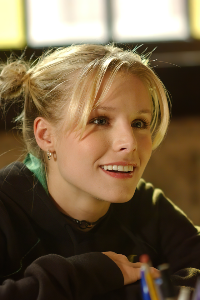 Улыбающаяся актриса Кристен Белл сидит в классе 