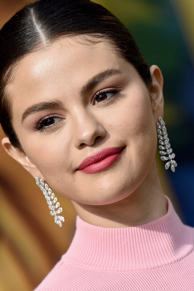 Улыбающаяся актриса и певица Селена Гомез с сережками в ушах