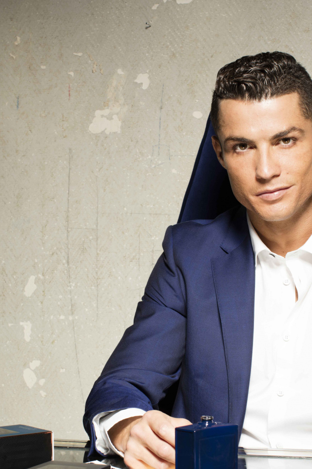 Стильный мужчина, футболист Криштиану Роналду с духами за столом