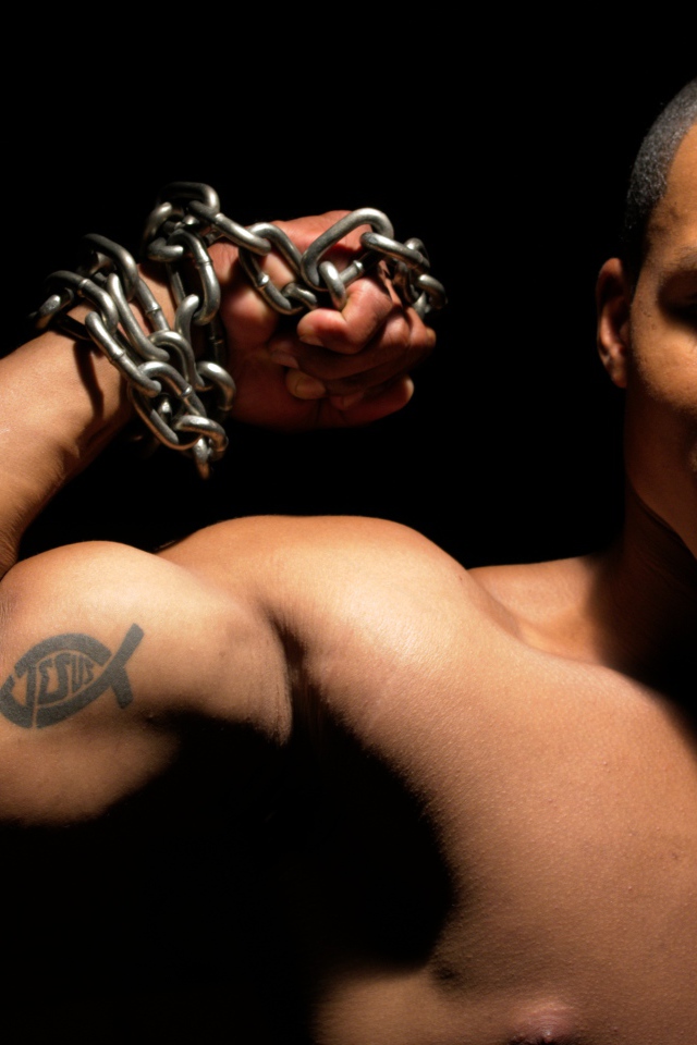 Татуировка на руке у накаченного мужчины на черном фоне