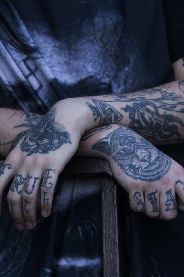 Татуировки на руках у парня в черной футболке 