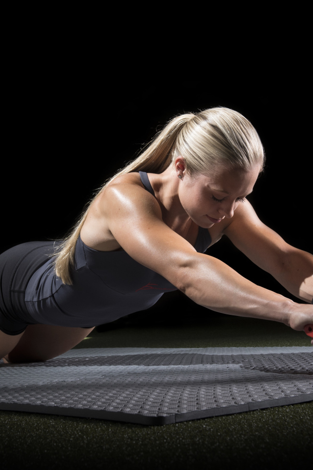 Девушка занимается фитнесом с колесом