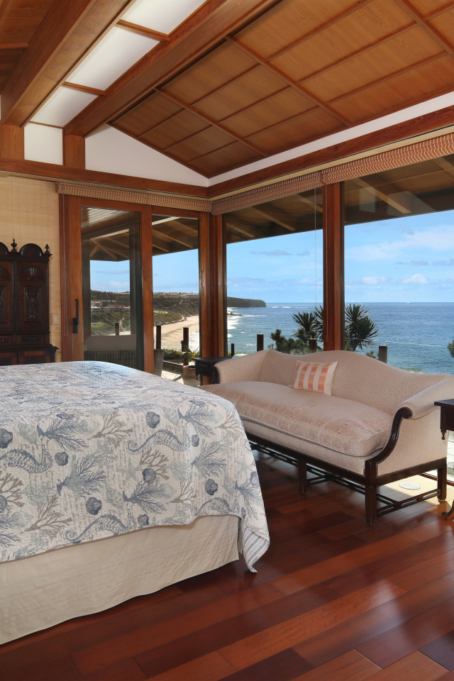 Деревянная спальня с большой кроватью и видом на море 