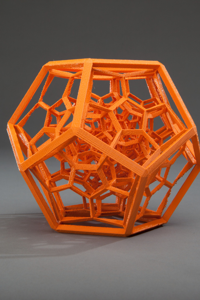 Оранжевый многогранник на сером фоне 3д