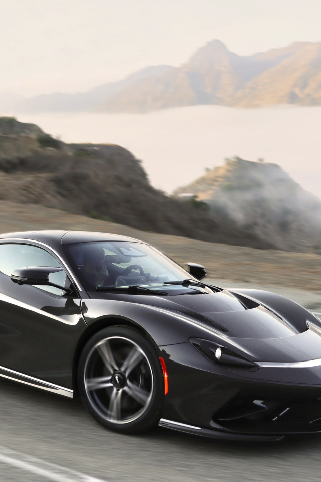 Черный спортивный автомобиль Pininfarina Battista,  2022 года на трассе