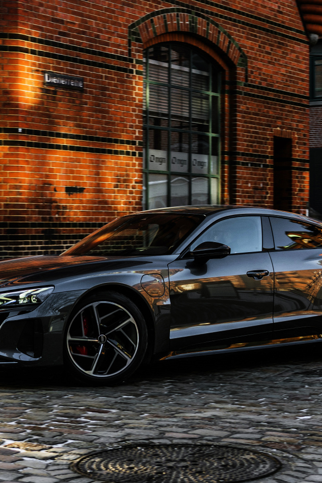 Черный автомобиль Audi RS E-Tron GT 2021 года у здания