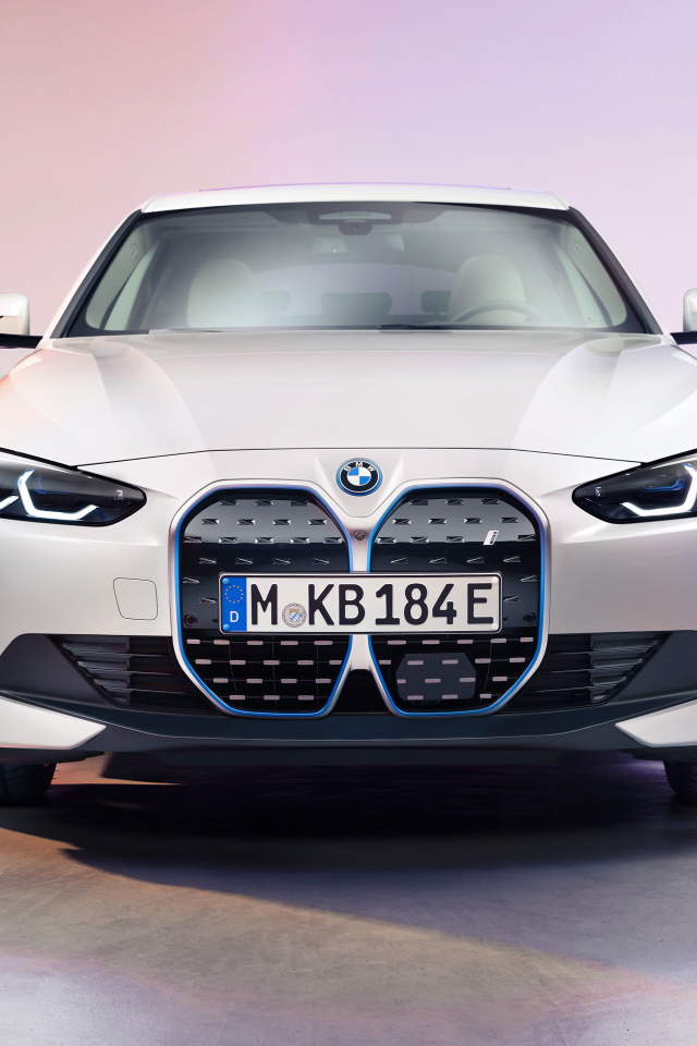 Автомобиль BMW I4 2021 года вид спереди на розовом фоне