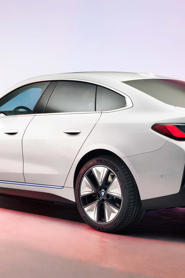 Белый автомобиль BMW I4 2021 года на розовом фоне