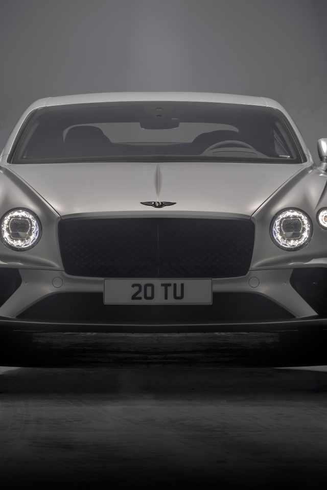 Серебристый автомобиль Bentley Continental GT Speed 2021 года на сером фоне