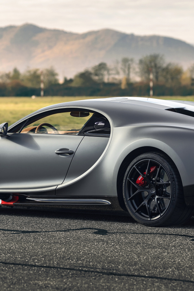 Серебристый спортивный автомобиль Bugatti Chiron  вид сзади