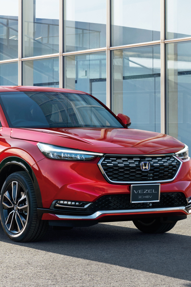 Красный автомобиль Honda Vezel EHEV 2021 у здания