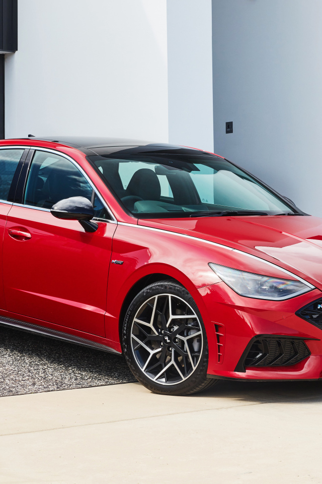 Красный автомобиль Hyundai Sonata N Line 2021 года у гаража