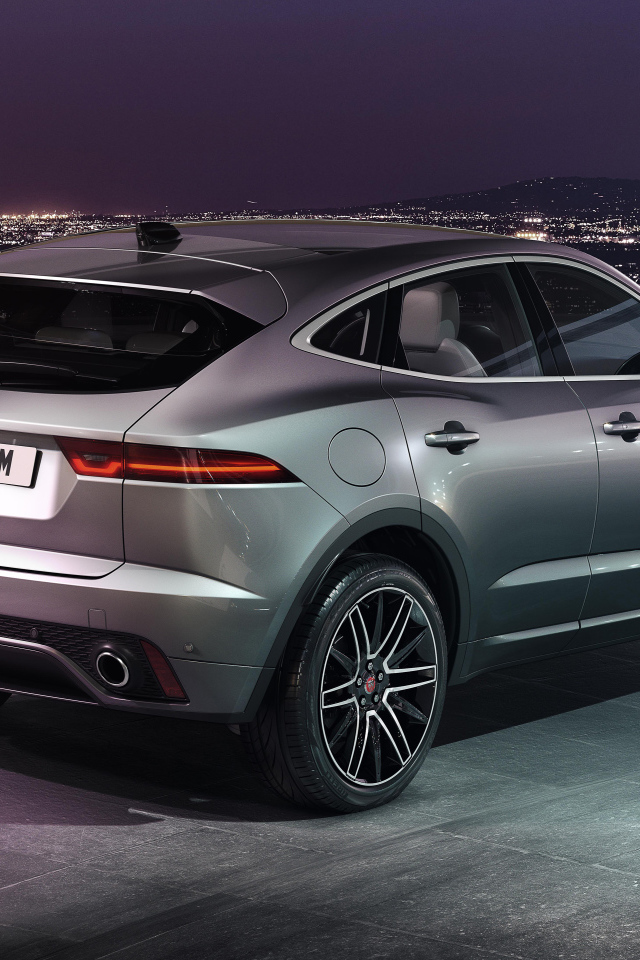 Серебристый Jaguar E-Pace R-Dynamic 2021 года на фоне ночного города