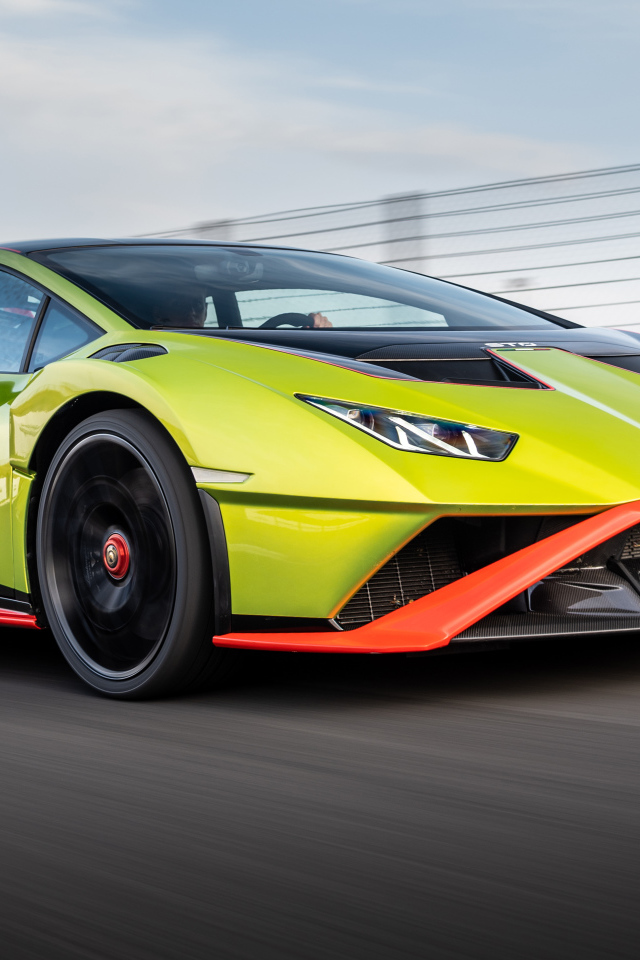 Зеленый автомобиль Lamborghini Huracán STO 2021 года на высокой скорости 