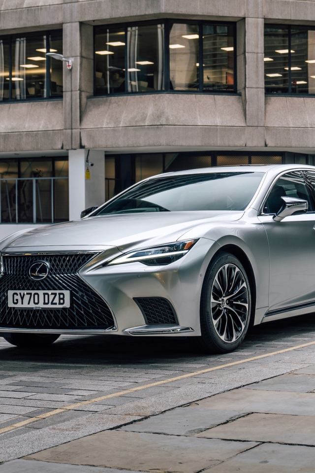 Серебристый автомобиль Lexus LS 500h 2021 года в городе у дома
