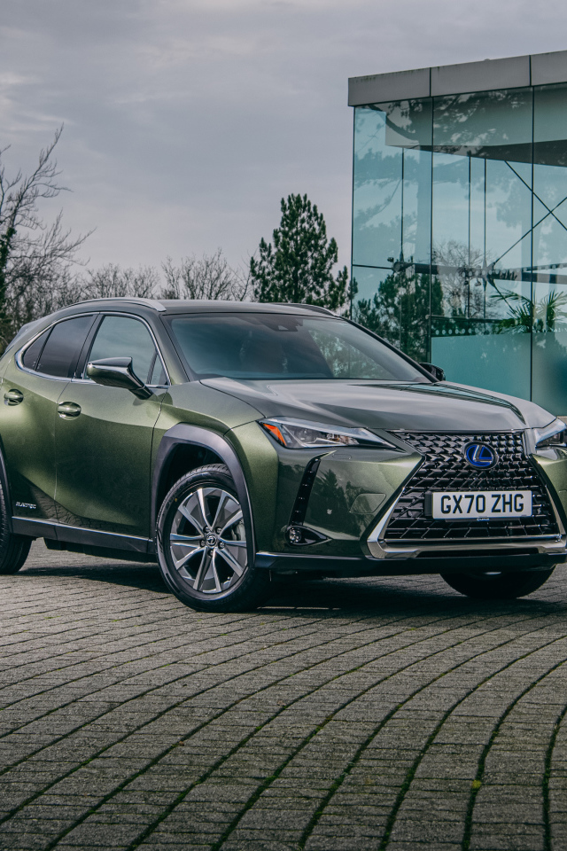 Зеленый автомобиль Lexus UX 300e 2021 года у стеклянной стены
