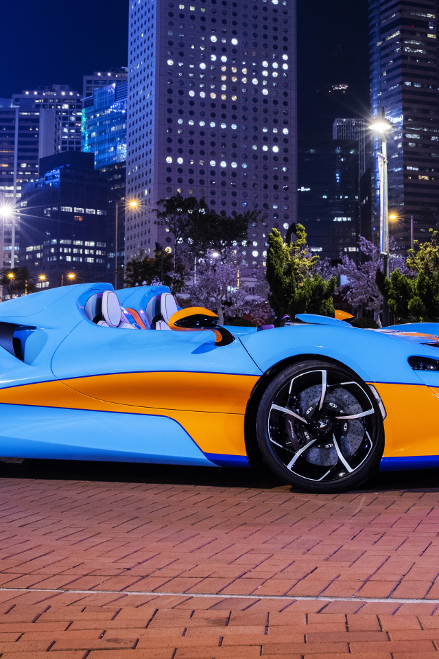 Автомобиль McLaren Elva Gulf Theme, 2021 года на фоне города