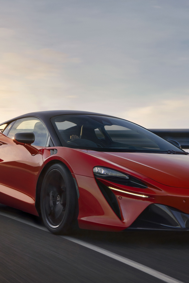 Красный быстрый автомобиль McLaren Artura, 2021 года на трассе