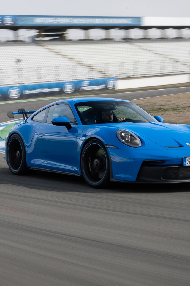 Голубой автомобиль Porsche 911 GT3 2021 года на стадионе